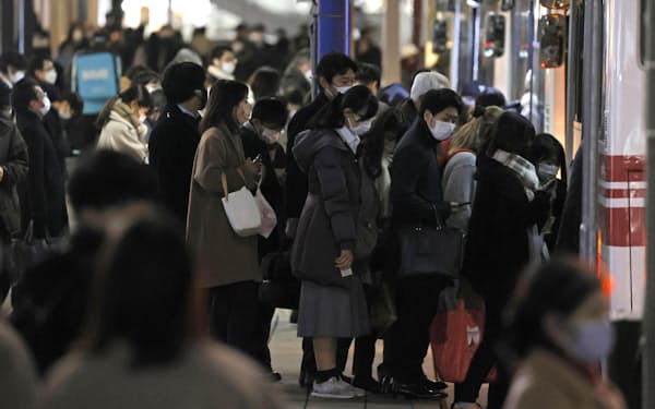 　マスク姿（すがた）でバスに乗りこむ人たち＝18日、福岡市のJR博多（はかた）駅前