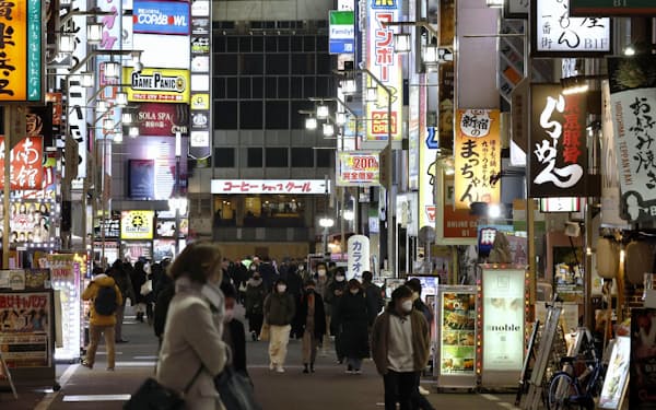 「まん延防止等重点措置」が適用された東京・新宿の歌舞伎町を歩く人たち（21日夜）