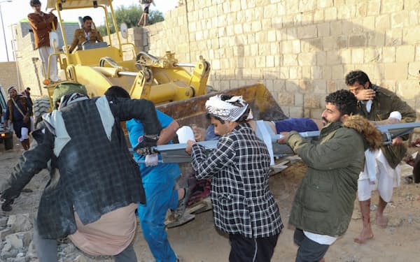 空爆現場で進む負傷者の救出作業（21日、イエメン北部サーダ）=ロイター