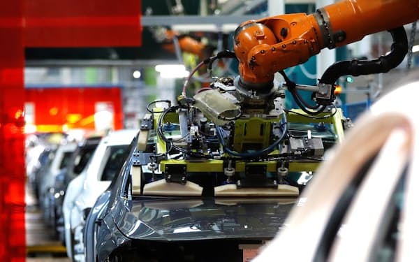 メルセデス・ベンツのドイツ工場で車体にガラスを装着するロボット＝ロイター