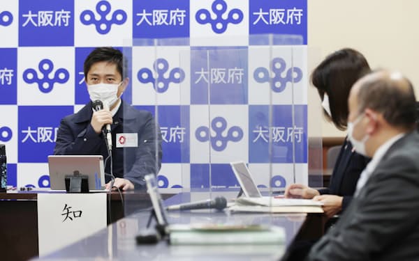 新型コロナウイルスの対策本部会議で発言する吉村知事（左）=25日、大阪府庁