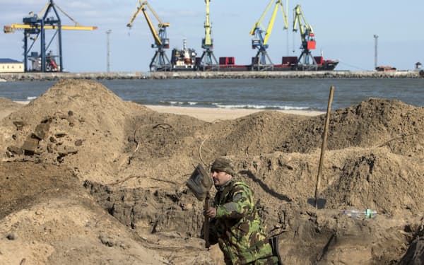 2015年の危機の際、マリウポリの海岸で塹壕（ざんごう）を掘るウクライナの兵士=ロイター