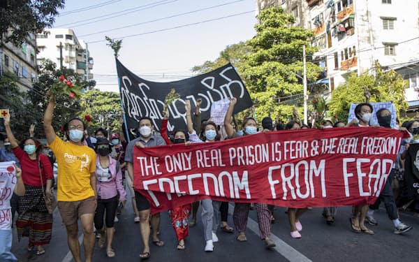 クーデターへの反発は根強い（2021年12月、ヤンゴンで国軍への抗議を表明する市民ら）＝AP