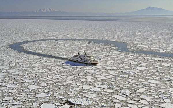北海道・網走沖で、流氷に覆われた海面をかき分けるように進む観光砕氷船＝21年1月、共同通信社ヘリから
