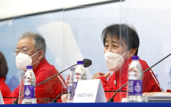 　記者会見する北京冬季五輪日本選手団の原田総監督。左は伊東団長（13日、北京）＝共同