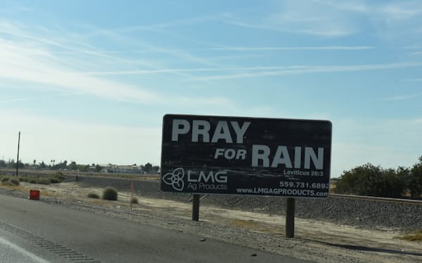 高速道路脇に「雨が降ることを祈ろう」と書かれた看板（21年10月、カリフォルニア州）=ロイター