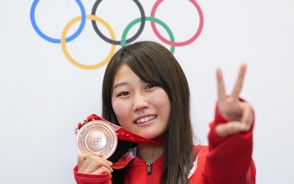 スノーボード女子ビッグエアで銅メダル獲得から一夜明け、記者会見後にポーズをとる村瀬心椛（16日、北京）＝共同