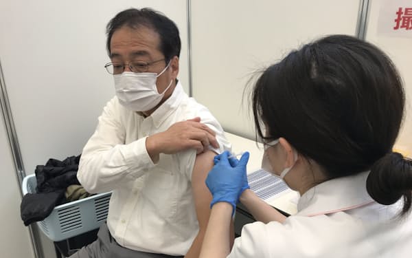 名古屋市が設置した大規模接種会場でモデルナ製ワクチンを接種する男性（9日、名古屋国際会議場）