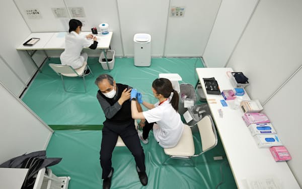 自衛隊大規模接種会場で新型コロナウイルスワクチンの接種を受ける男性（14日午前、大阪市中央区の日経今橋ビル）
