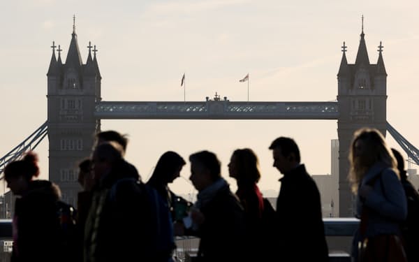 朝のラッシュアワーにロンドン橋を渡って通勤する人たち＝ロイター