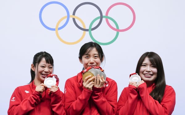 スピードスケート女子の全競技を終えて一夜明け、メダルを手に笑顔でポーズをとる3選手。左から高木菜那、高木美帆、佐藤綾乃（20日、北京）＝共同