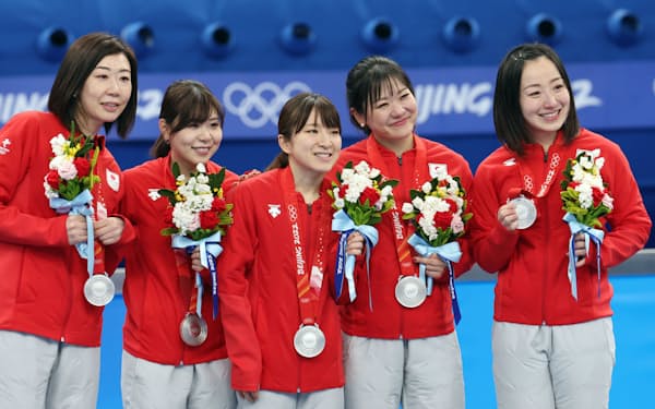 銀メダルを胸に笑顔で記念写真に納まるカーリング女子日本代表のロコ・ソラーレ＝上間孝司撮影