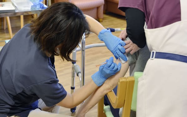 横浜市の高齢者施設で新型コロナワクチンの3回目接種を受ける入所者（21年12月）＝横浜市提供・共同