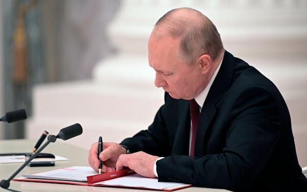 21日、ウクライナ東部の親ロシア派地域独立承認の文書に署名するロシアのプーチン大統領＝ＡＰ