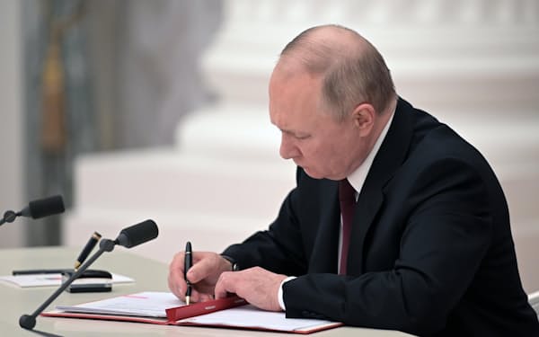 　21日、ウクライナ東部の親ロシア派地域独立承認の文書に署名するロシアのプーチン大統領（モスクワのクレムリン）＝AP