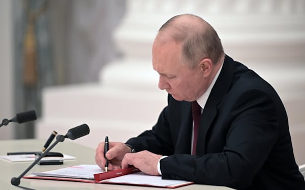 21日、ウクライナ東部の親ロシア派地域独立承認の文書に署名するロシアのプーチン大統領(モスクワのクレムリン)=AP