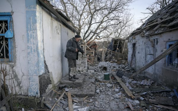 ウクライナ東部ドネツク州で砲撃された建物を案内する地元住民（20日）＝ロイター