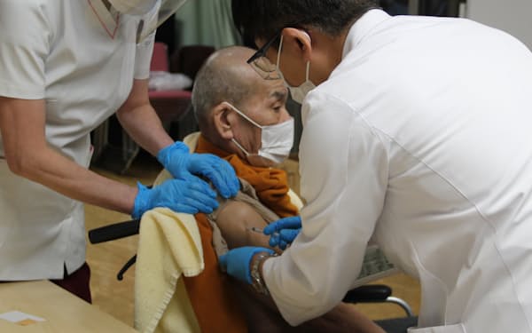 コロナワクチンの3回目接種費用などで予算規模は膨らんだ(江東区内で3回目接種を男性、21年12月撮影)