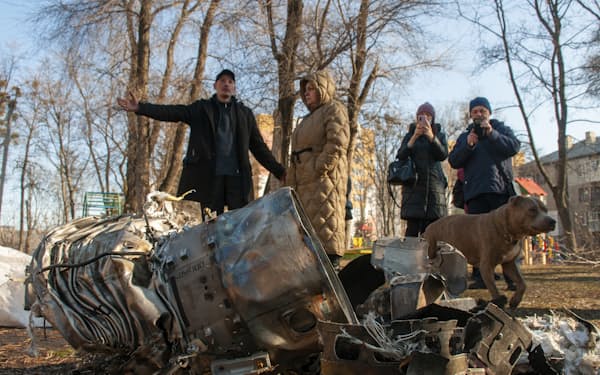 24日、攻撃後の残骸をみるウクライナの市民（同国北東部ハリコフ）＝ＡＰ