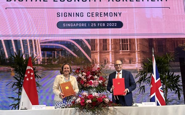 デジタル経済協定に署名するシンガポールのイスワラン貿易担当相（右）と英国のトレベリアン国際貿易相（25日、シンガポール）