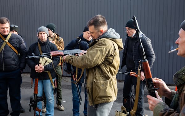 銃器を受け取る自警団メンバー（25日、キエフ）＝ロイター