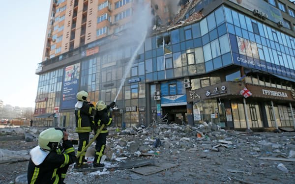 キエフで空爆された建物の消火活動をする消防士（26日）＝ロイター