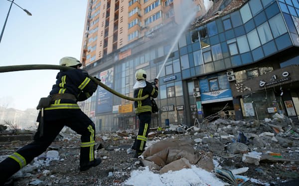 26日、キエフで砲撃を受けた集合住宅の消火活動をする消防士＝ロイター