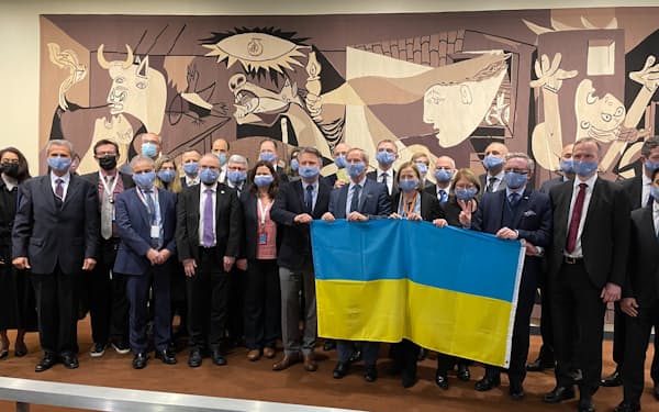 反戦を訴えるピカソの「ゲルニカ」のタペストリーの前でウクライナへの連帯を示す国連大使ら（25日、ニューヨークの国連本部）