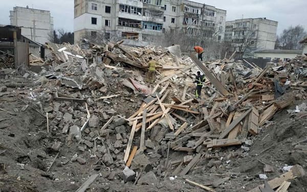 People are seen among debris of residential buildings damaged by shelling, amid the Russian invasion of Ukraine, in Zhytomyr region, Ukraine, in this handout picture released March 7, 2022.  Press service of the State Emergency Service of Ukraine/Handout via REUTERS ATTENTION EDITORS - THIS IMAGE HAS BEEN SUPPLIED BY A THIRD PARTY.