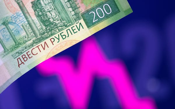 A Russian rouble banknote is seen in front of a descending stock graph in this illustration taken March 1, 2022. REUTERS/Dado Ruvic/Illustration