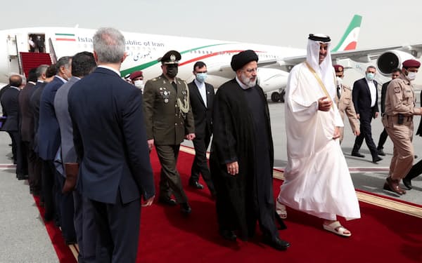 イランのライシ大統領（前列の右から２人目）を迎え、並んで歩くカタールのタミム首長（2月、ドーハ）＝ロイター