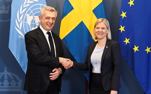9日、ストックホルムでグランディ国連難民高等弁務官（左）と握手するスウェーデンのアンデション首相＝ロイター