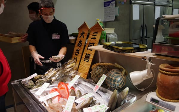 魚 の特徴を説明しながら販売する（下の一色魚市場、名古屋市）