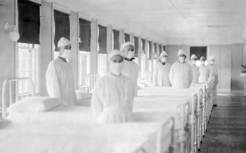 米国海軍病院のインフルエンザ 病棟でマスクを着用した衛生兵たち。米カリフォルニア州のマレ島で撮影。スペインかぜのパンデミックでは、第一次世界大戦がもたらした医療スタッフ不足にも悩まされた。（ALAMY）