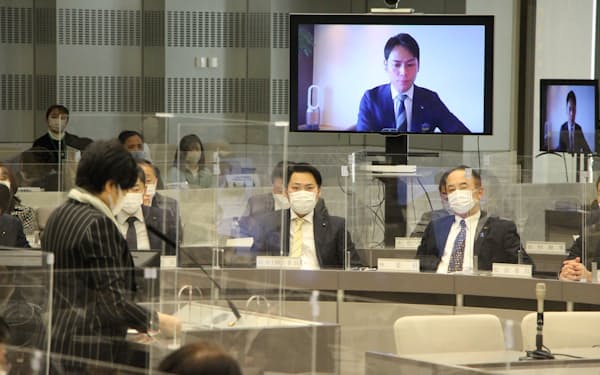 東京都議会の予算特別委員会でオンライン出席した都議（モニター画面）に答弁する小池知事㊧（３月９日）