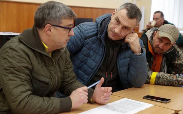 報告を受けるキエフ市のクリチコ市長㊥（11日、キエフ）＝ロイター