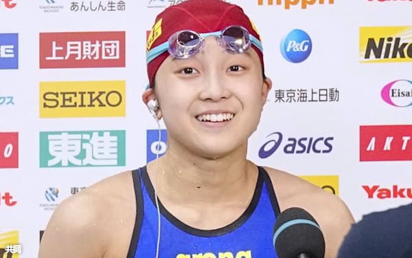 女子400メートル個人メドレー決勝のレースを終え、笑顔でインタビューに答える成田実生=共同