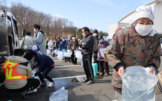 断水が発生した福島県南相馬市で、給水車に並ぶ人たち（17日）