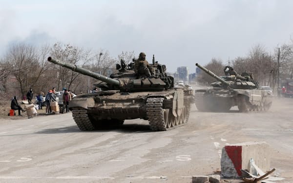 ウクライナ南東部マリウポリ郊外を走行する、ロシア側のものとみられる戦車（20日）=ロイター