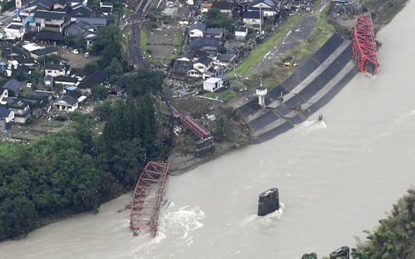 　2020年7月の豪雨で被害を受けた熊本県球磨村。球磨川（手前）に架かるJR肥薩線（左）と車道の橋は流された＝共同
