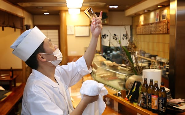 夜の営業に向けて開店の準備をする「寿司割烹　から津」の職人（22日午後、大阪市）
