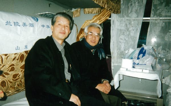 生産本部長時代、北京発の夜行列車で現地工場へ向かう（左が筆者）