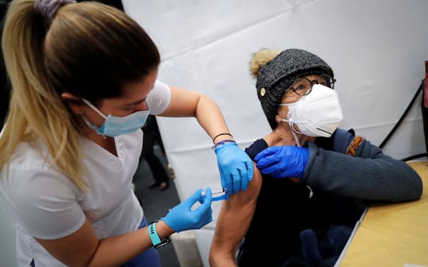 新型コロナウイルスのワクチンを接種する女性（ニューヨーク市）＝ロイター