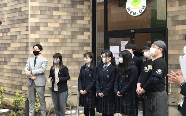 新業態ラーメン店の開店イベントで川崎さん（左から２人目）が高校生らとあいさつする様子