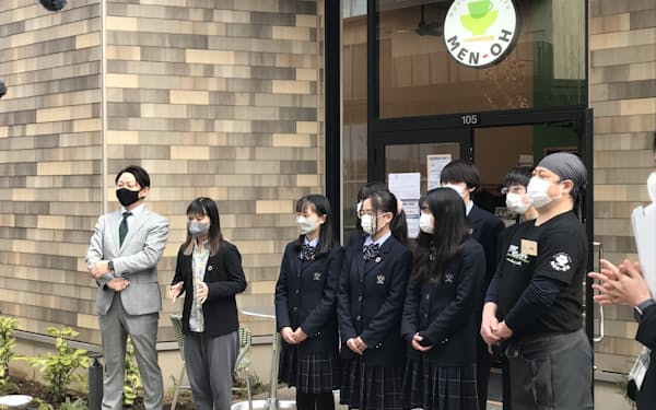 新業態ラーメン店の開店イベントで川崎さん(左から2人目)が高校生らとあいさつする様子