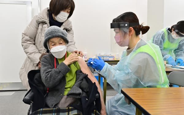 集団接種会場で３回目の接種を受ける高齢者（20日、大阪市中央区）