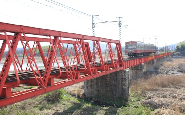 登録有形文化財の愛知川橋梁を渡る近江鉄道の電車