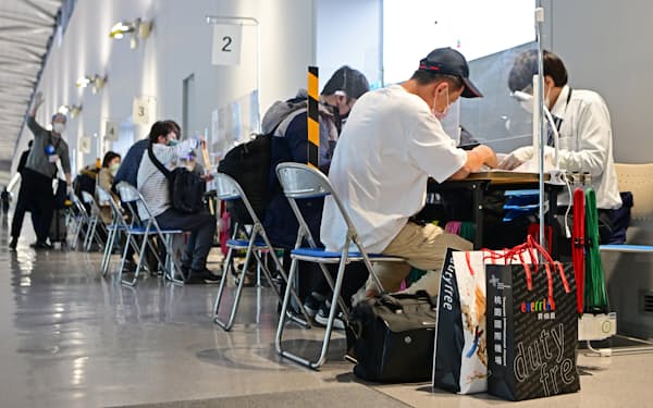 関西国際空港で入国者の陰性証明書などを確認する検疫所の職員ら（3月1日）