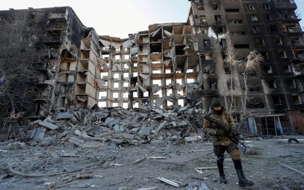 破壊された建物と親ロシア派武装勢力の兵士＝28日、ウクライナ南東部マリウポリ（ロイター）