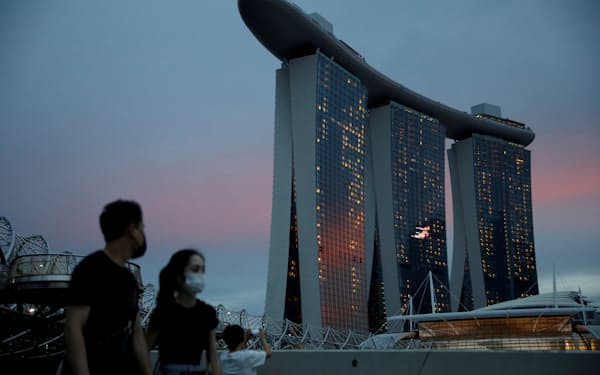 FILE PHOTO: People wearing face masks pass the Marina Bay Sands hotel during the coronavirus disease (COVID-19) outbreak, in Singapore October 28, 2021. REUTERS/Edgar Su/file photo/File Photo